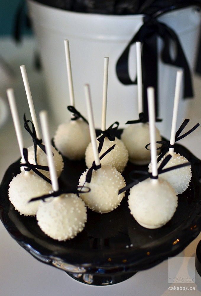 white chocolate covered candies on a black plate