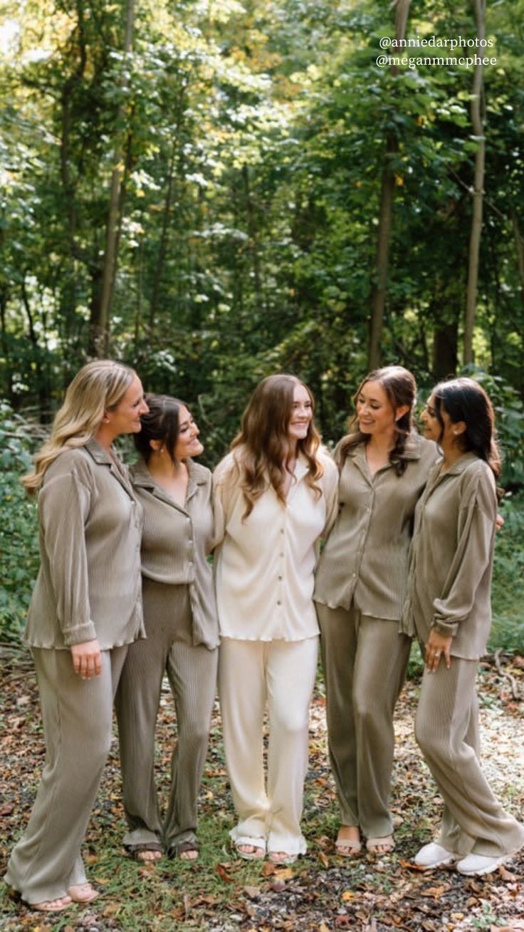 the bride and her bridesmaids pose for a photo in the woods at their wedding