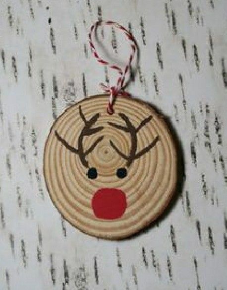 a wooden ornament with a reindeer's face and red nose on it