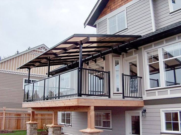 a house with a covered patio in front of it and lots of windows on the second floor