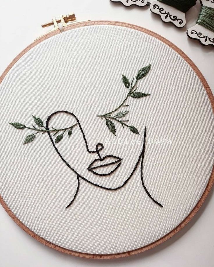 the embroidery is being worked on with scissors and thread to make it look like a woman's face