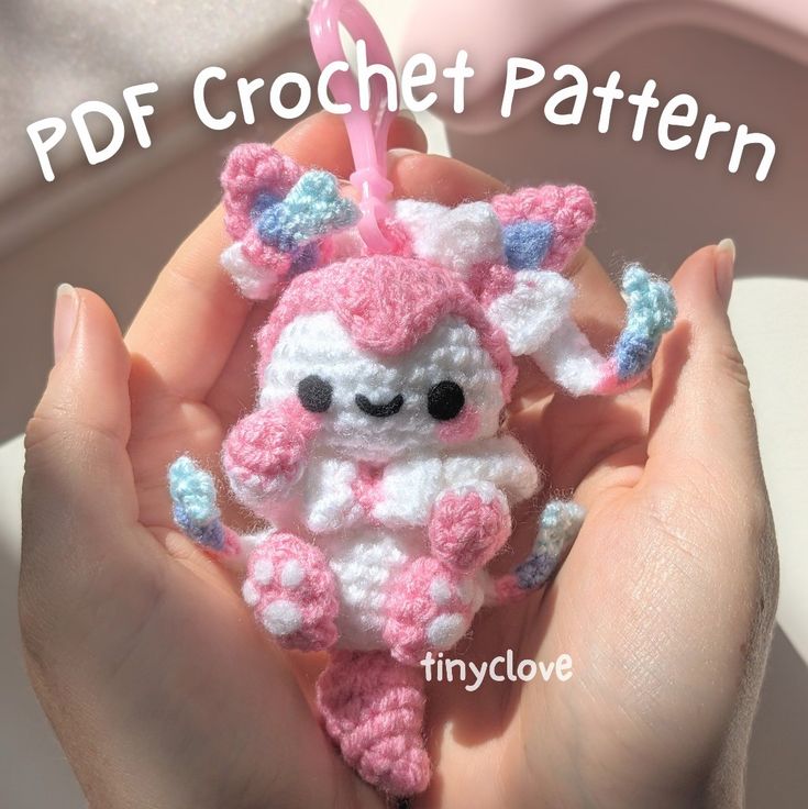 a crocheted pink and white stuffed animal in someone's hand with text overlay that reads, pdf crochet pattern