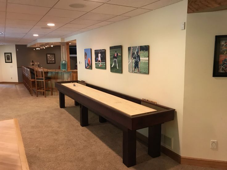 a room with a pool table and pictures on the wall