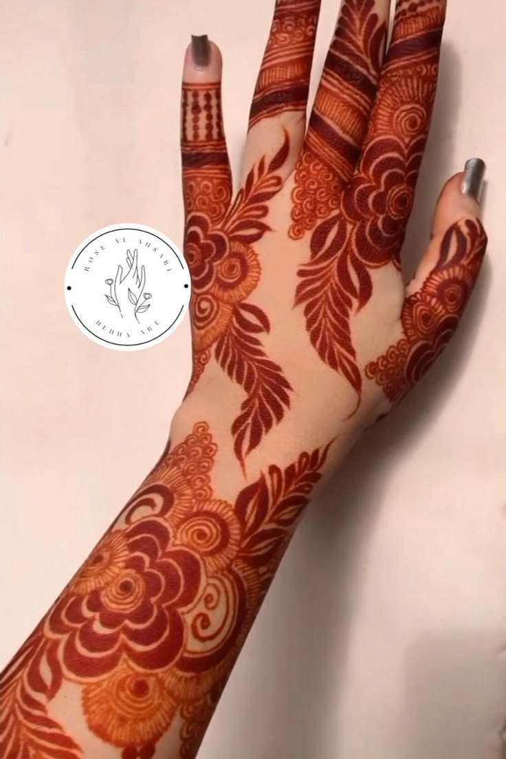 a woman's hand with henna tattoos on it