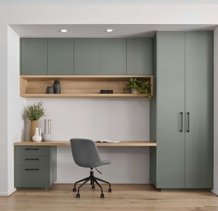 an office area with desk, chair and cabinets in grey color on wooden flooring