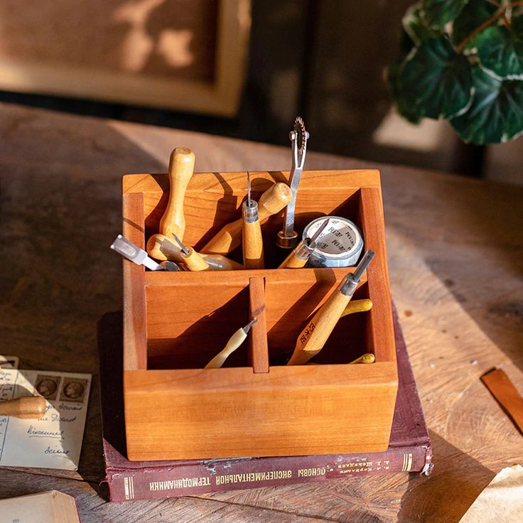 a wooden box filled with tools on top of a table