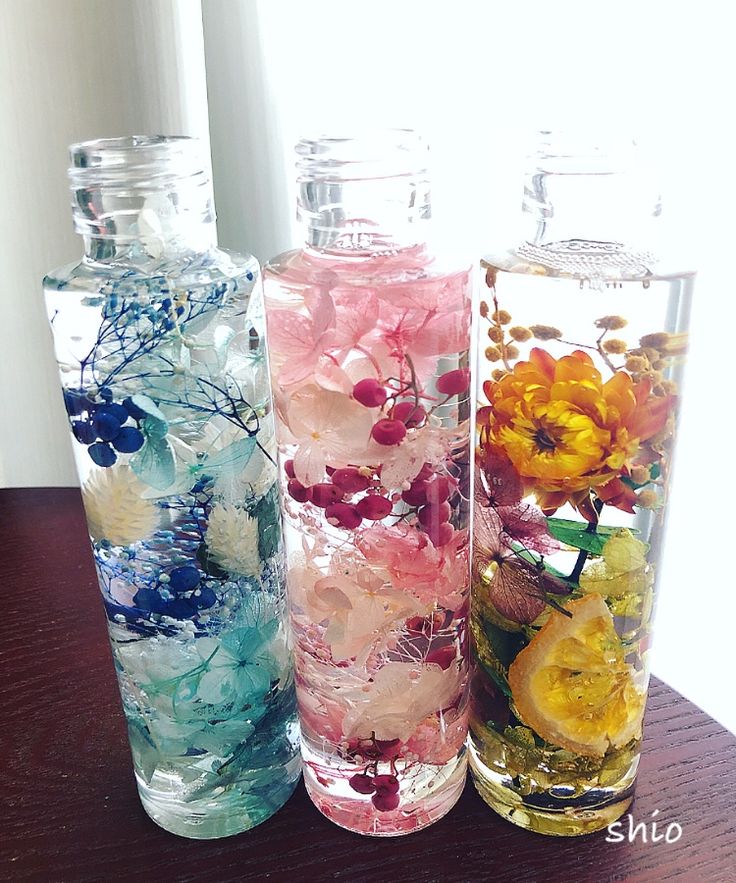 three glass vases with flowers in them sitting on a table