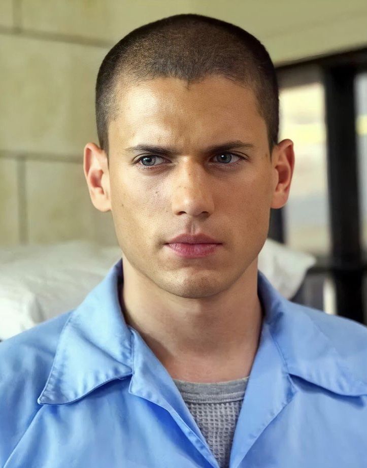 a young man in a blue shirt is staring at the camera