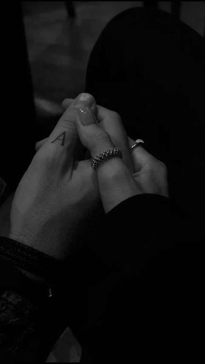 two people holding hands in the dark with their fingers touching each other's foreheads