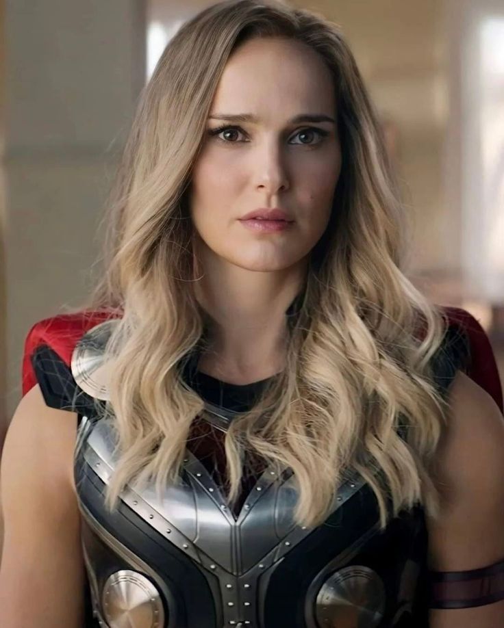 a woman in a black and red dress with long blonde hair wearing a silver armor