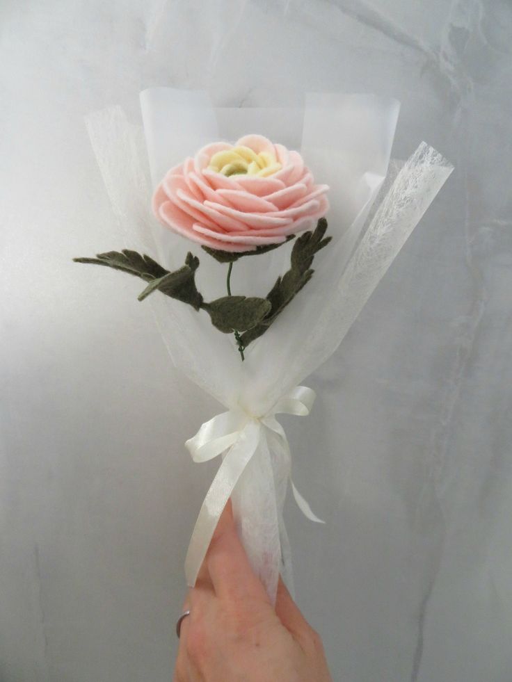 a person is holding a fake flower in their hand