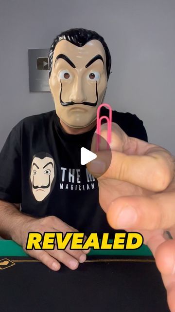 a person wearing a fake mask holding a cell phone in front of their face with the caption revealed