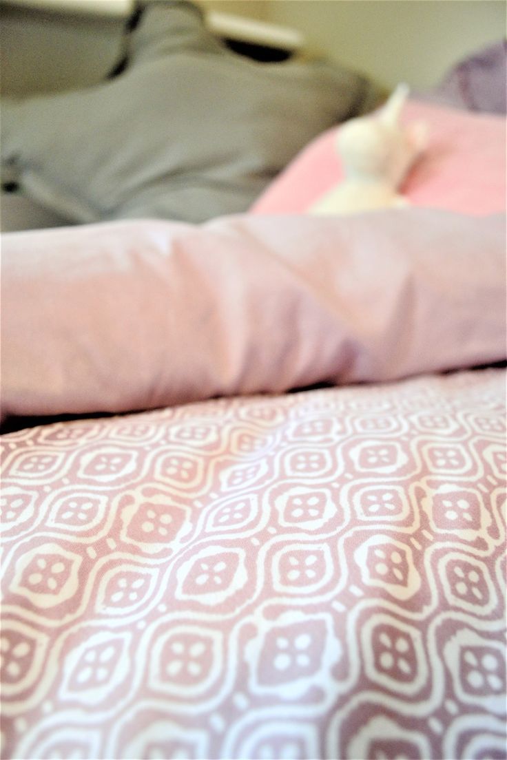 a bed with pink and white sheets on it