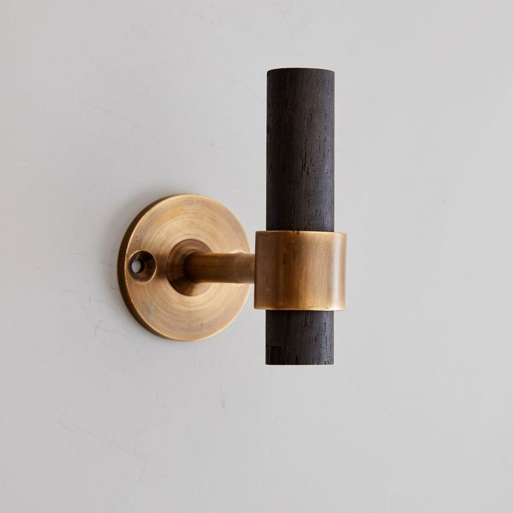 a close up of a wall light on a white wall with a black pole attached to it