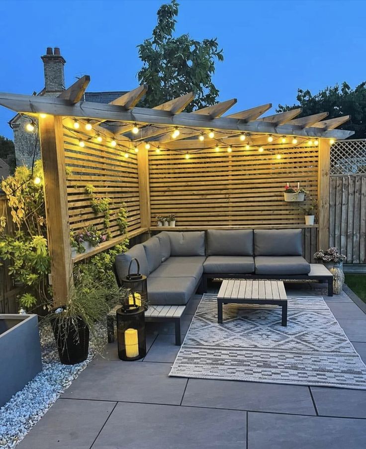 an outdoor living area with patio furniture and string lights on the pergolated roof