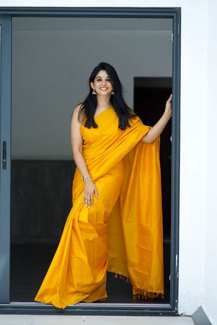 a woman in a yellow sari is posing for the camera