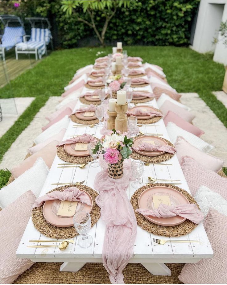 the table is set with pink and gold plates