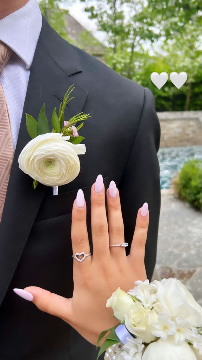 a man in a suit and tie with his hand on the bride's finger