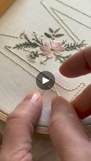 someone is stitching flowers on a piece of fabric