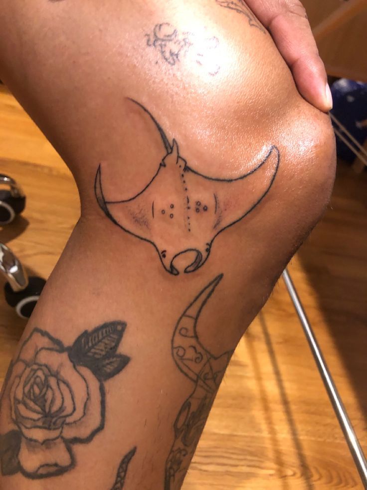 a tattoo on the leg of a person with a rose and cow's head