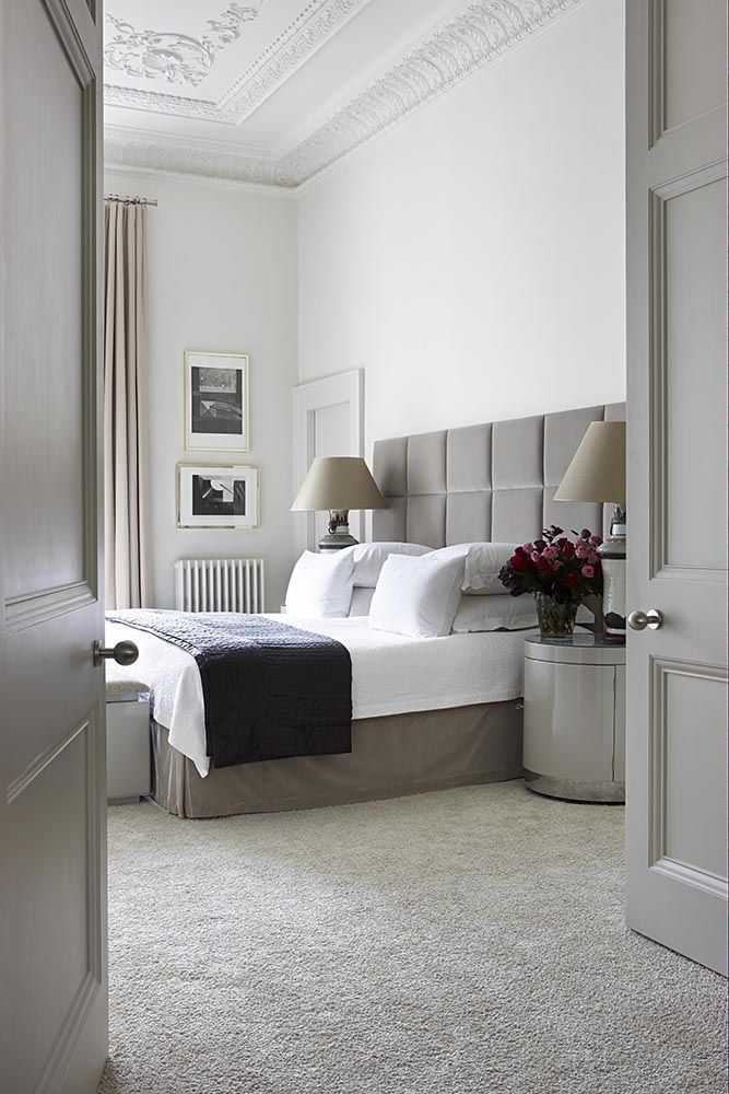 a bedroom with white walls and carpeted flooring