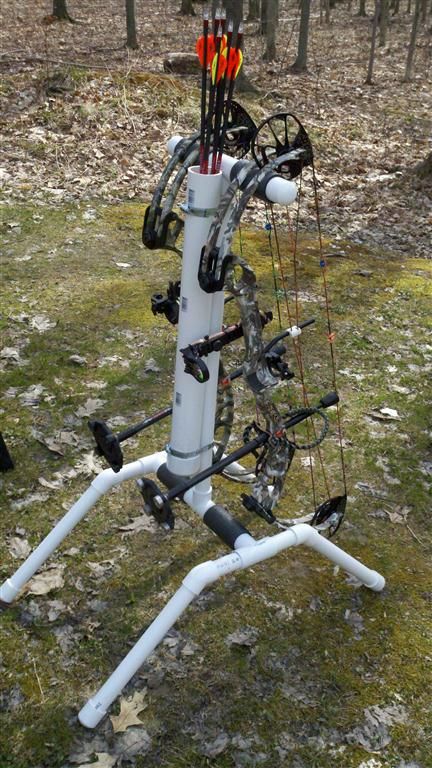 an archery set up in the woods with arrows and bows on it's back