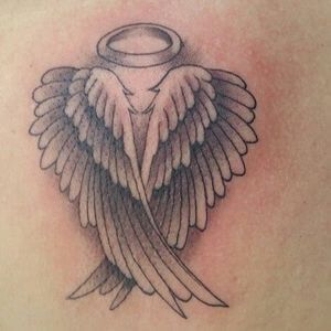 the back of a woman's shoulder with an angel tattoo design on her chest