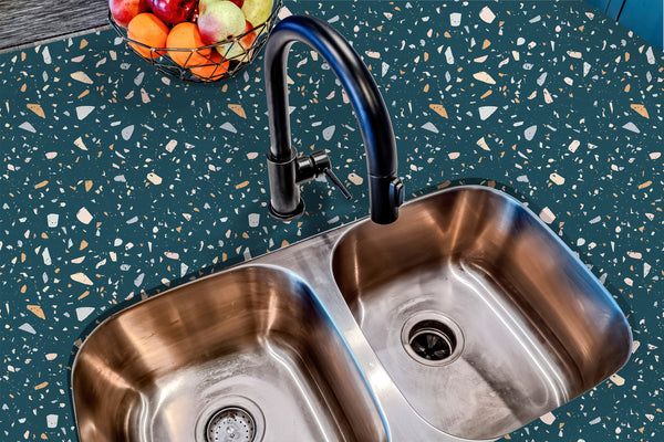 two stainless steel sinks in a kitchen next to a bowl of fruit