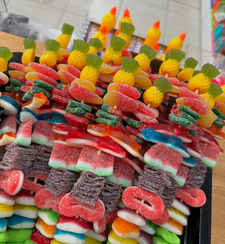 a tray filled with lots of candy covered in gummy bears and corn on the cob