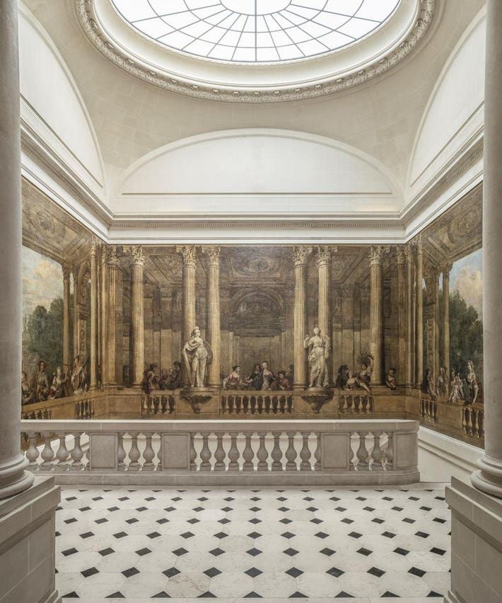 an ornate room with columns and paintings on the wall