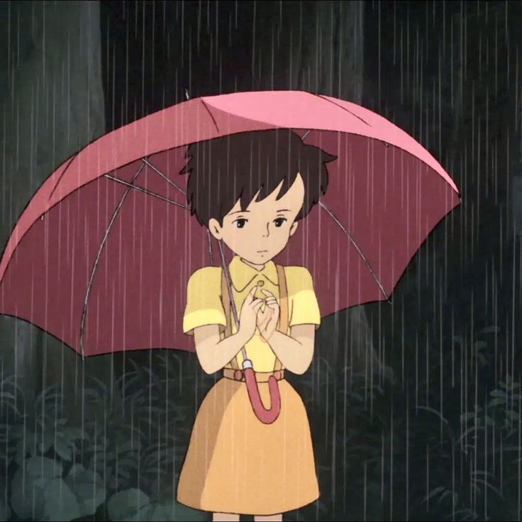 a girl holding an umbrella in the rain with her hands clasped to her chest while standing under it