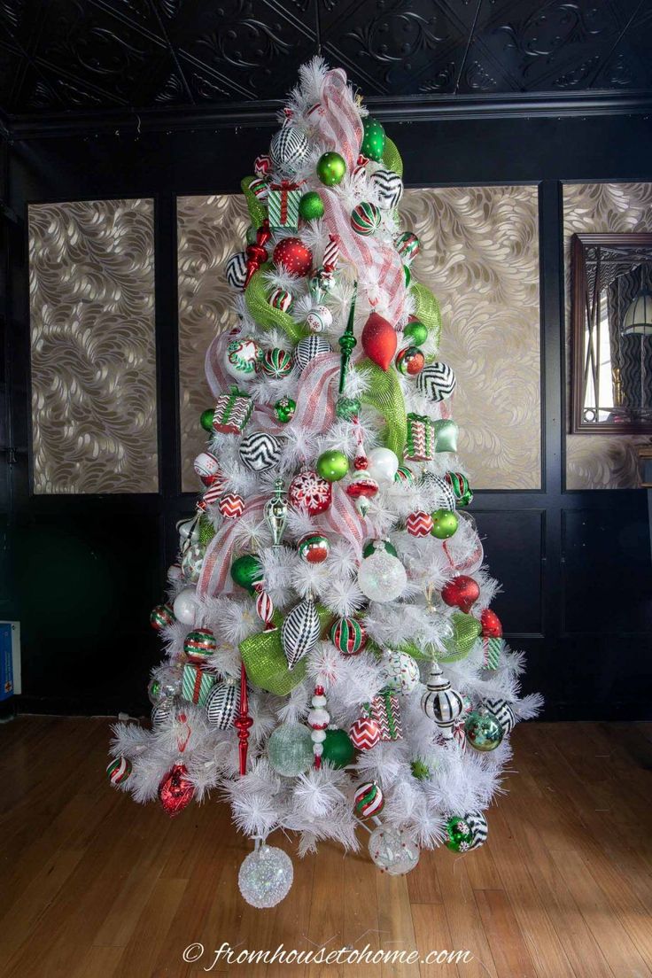 a white christmas tree with green and red ornaments