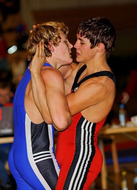 two men in wrestling uniforms embracing each other