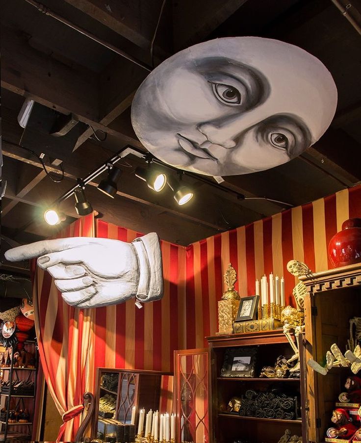 a large white glove hanging from the ceiling in front of a red and white striped wall