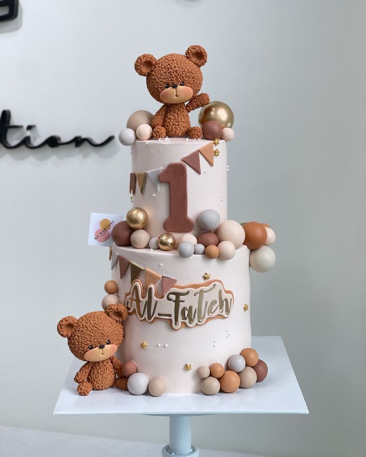 a three tiered cake with teddy bears on top and decorations around the bottom layer