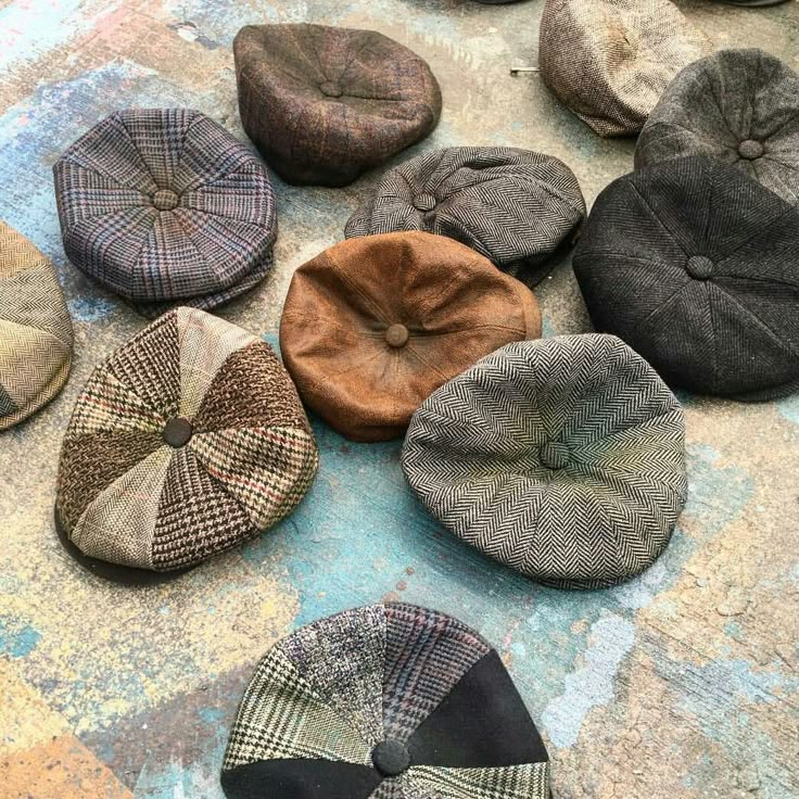 several hats are laid out on the ground with different colors and patterns, including plaid