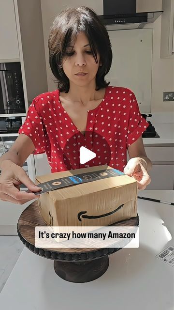 a woman holding a box with an amazon logo on it and the caption, it's crazy how many amazon boxes are made