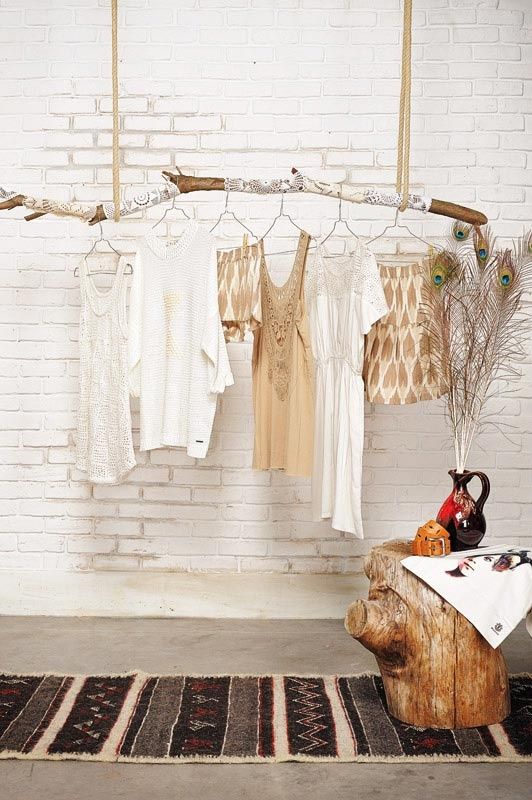 clothes are hanging on the clothes line in front of a white brick wall and rug