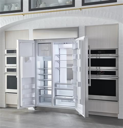 an open refrigerator with its doors wide open in a kitchen area that has white walls and gray flooring