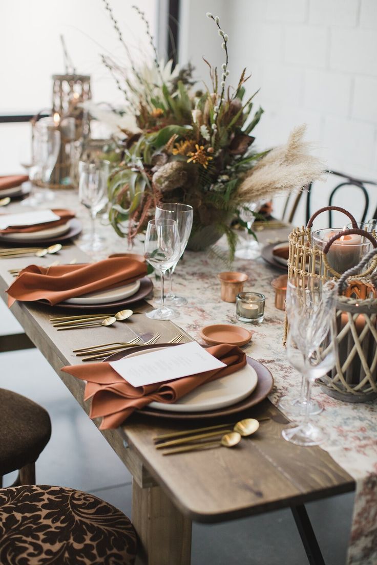 the table is set with place settings, napkins, and wine glasses for dinner