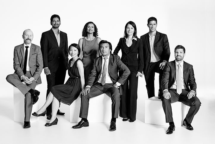 a group of people posing for a black and white photo with one man in the middle