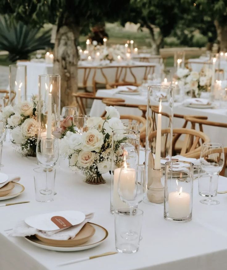 the table is set with white flowers and candles