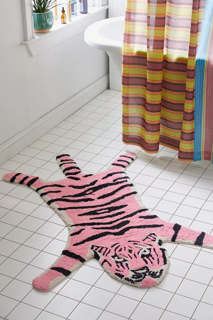 a bathroom with a rug that looks like a tiger laying on the floor next to a bathtub