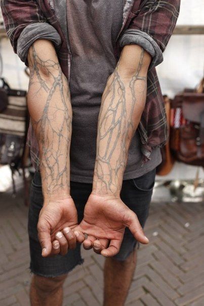 a man with tattoos on his arms and hands