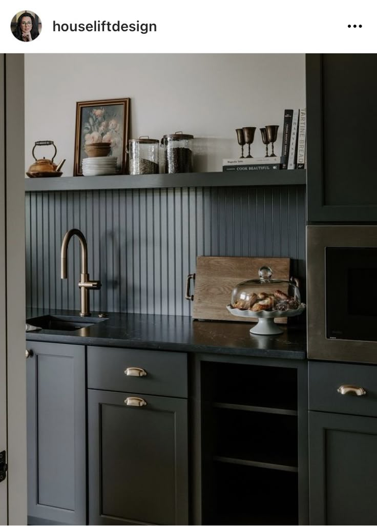 an image of a kitchen setting with black cabinets and stainless steel faucet in the middle