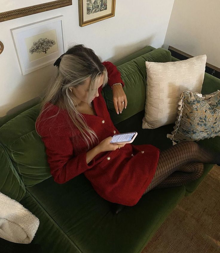 a woman sitting on top of a green couch