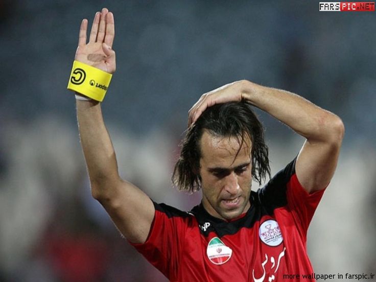 a male soccer player with his hand up in the air while wearing a yellow wristband