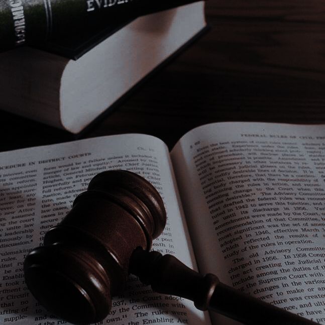 a judge's gavel sitting on top of an open book next to a law book