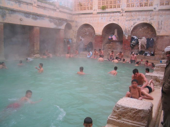 many people are swimming in a large pool