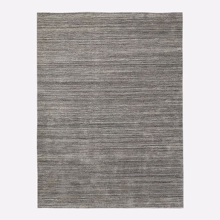 an area rug with grey and white stripes on the bottom, in front of a gray background